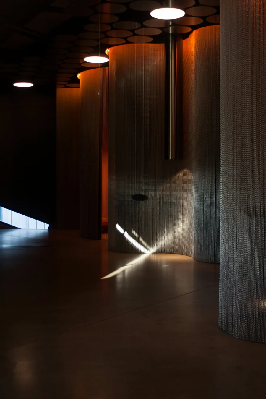 A dark corridor with a single beam of warm light.