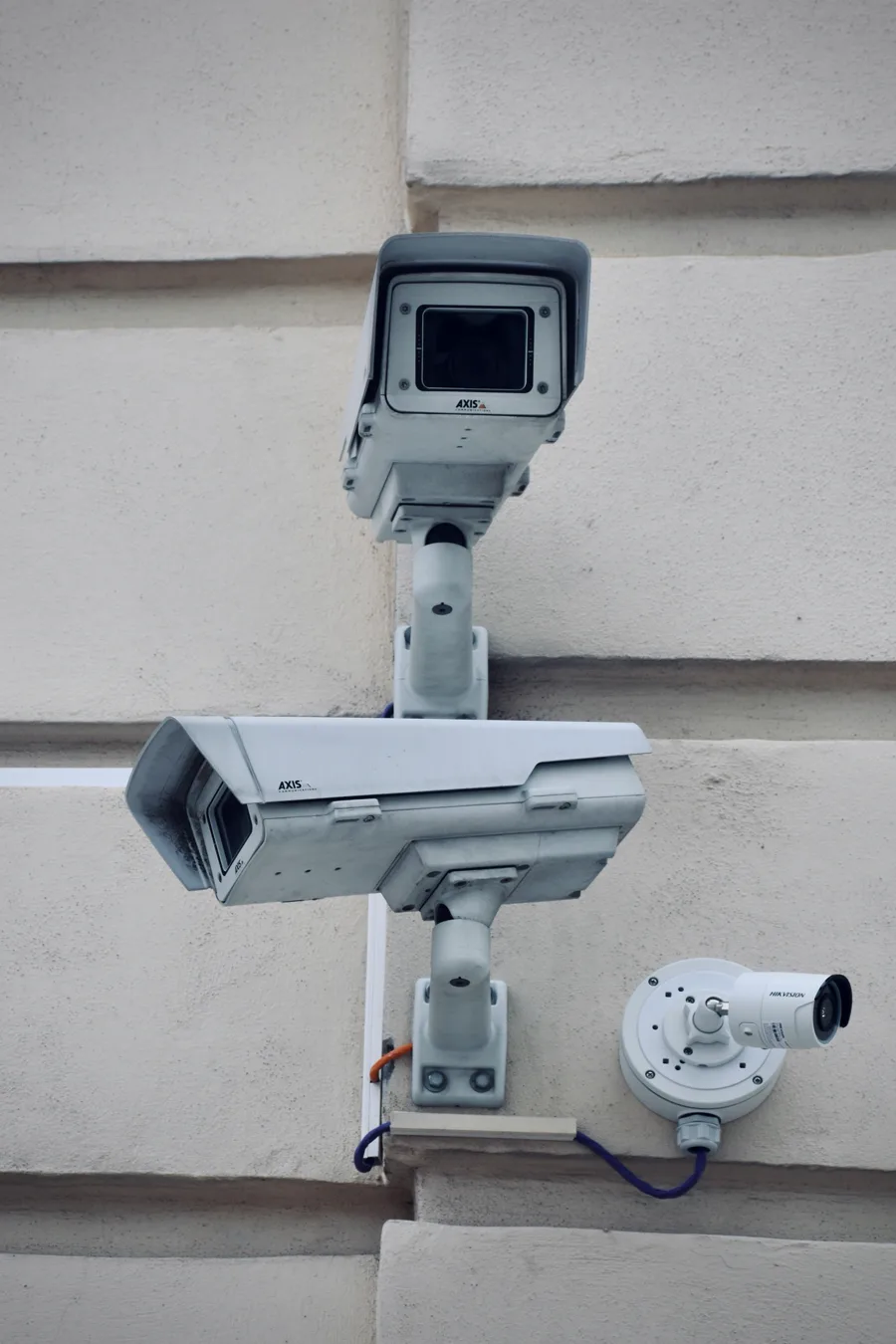 Security cameras on a stone facade.