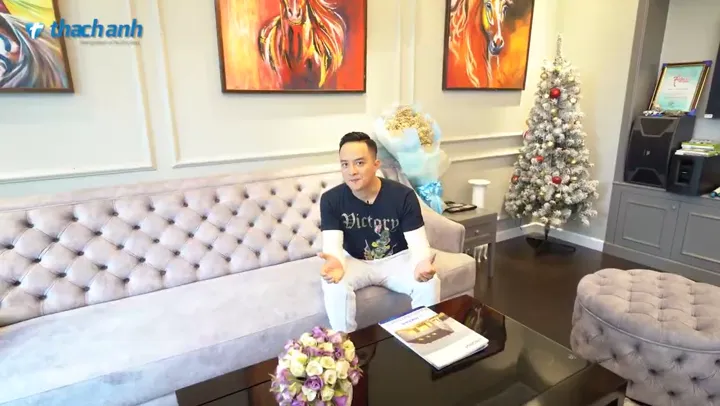Singer Cao Thái Sơn on a sofa in his living room.