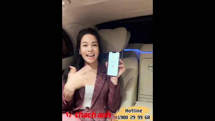Singer Nhật Kim Anh holding her phone in a car.